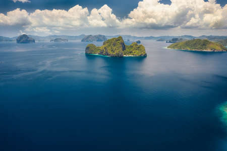 Aerial view the Entalula Island from the distance. Open ocean, white clouds at high altitude. Bacuit...