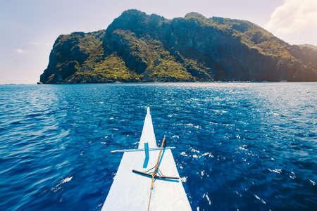 El Nido, Philippines. Front of Island hopping Tour boat hover over open blue ocean water facing exotic karst limestone island on travel tour tripの写真素材