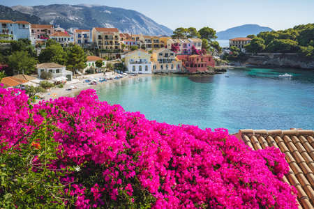 Assos on Cephalonia Kefalonia Ionian island in Greece. Vivid pink flower in foreground. Summer travel vacationの写真素材
