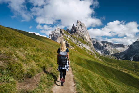 Women hiker on trail path and epic landscape of Seceda peak in Dolomites Alps, Odle mountain range, South Tyrol, Italy, Europeの写真素材