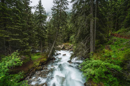 Mountain blue water river and trees landscape natural environment. Hiking in the alps. Grawa Waterfall in Stubai Valley, Tyrol, Austriaの写真素材