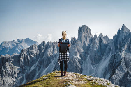 Woman hiker with backpack against Cadini di Misurina mountain group range of Italian Alps, Dolomites, Italy, Europeの写真素材