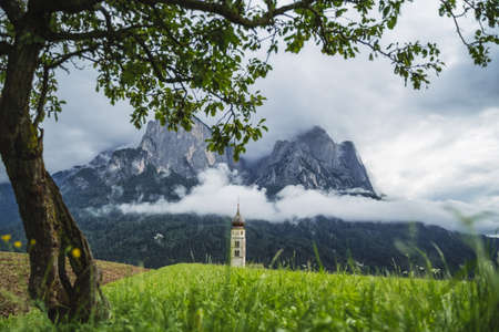 St Valentines Church, Seis am Schlern, Italy. Schlern mountain with rainy clouds in backgroundの写真素材
