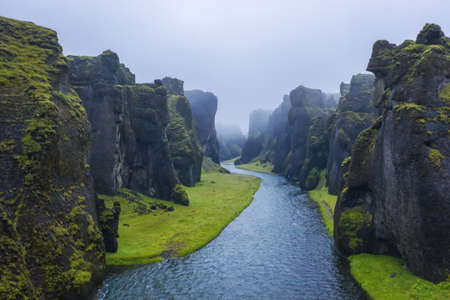 The famous and unique Fjadrargljufur valley in Iceland on a rainy day. Mossy cliffs and mountain river. Point of interest for tourists coming to visit Icelandの写真素材