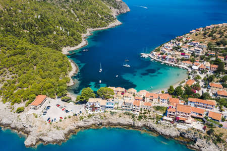 Assos picturesque fishing village from above, Kefalonia, Greece. erial drone view. Sailing boats...