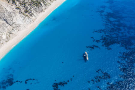 Lefkada, Greece. Remote white Egremni beach with lonely luxury yacht boat on the turquoise colored bay on Ionian Seaの写真素材