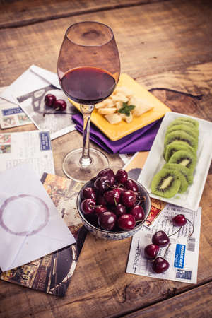 Kiwifruit, cherry and cheese with red wineの写真素材
