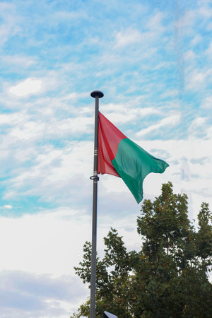 A Granada Flag Flying on Its Pole with Blue Clear Sky as the Backgroundの写真素材