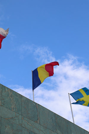The Romanian Flag Waving on Top of the Building with Other Nations Flagsの写真素材