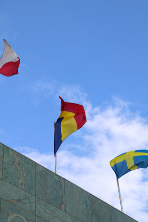 The Romanian Flag Waving on Top of the Building with Other Nations Flagsの写真素材