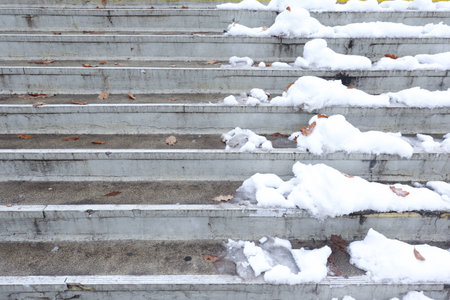 Half of the Stairs Have been cleared from the snow while the other half is still covered by snowの写真素材
