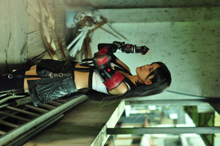 Beautiful asian woman in black latex costume posing in an abandoned building