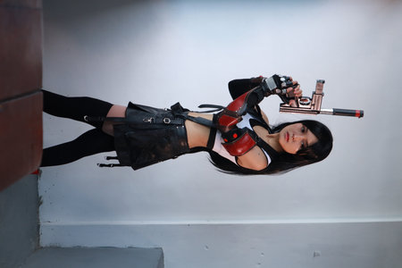 Portrait of a beautiful sexy woman in black latex costume with gun