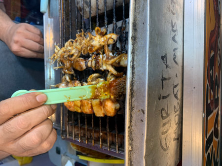 Tasty squids and octopus Grilled with skewers bamboo stick served in a outdoor street food market....