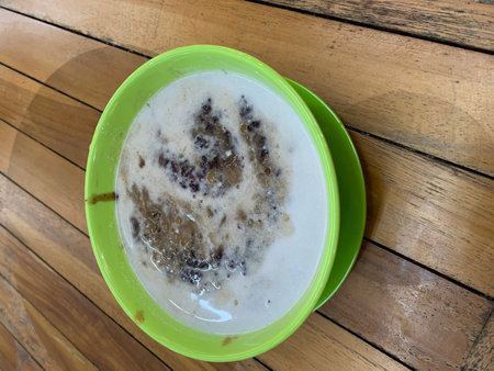 Coconut milk porridge in bowl on wooden table.の写真素材