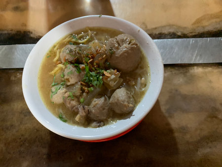Thai style pork noodle soup with pork ball in white bowl