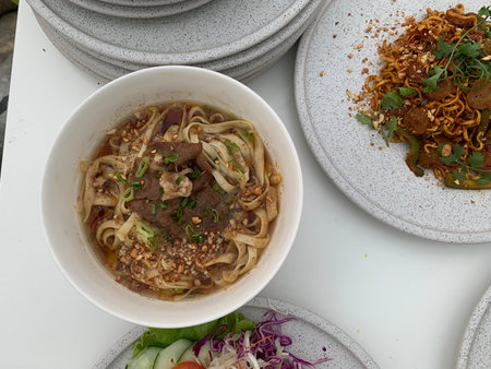Noodle soup with meat in white bowl on the table