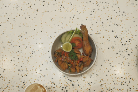 Fried fish with spicy and sour sauce in a plate on the tableの写真素材