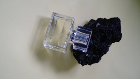 Perfume bottle with black coal on white background. Perfume bottle with black coal.の写真素材