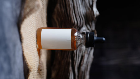 Essential oil in a bottle on a wooden background close-upの写真素材