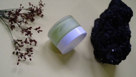 cosmetic cream on a white background with a black stone in the backgroundの写真素材