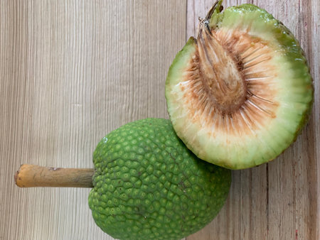 Close up of green maclura fruit on wooden table background.