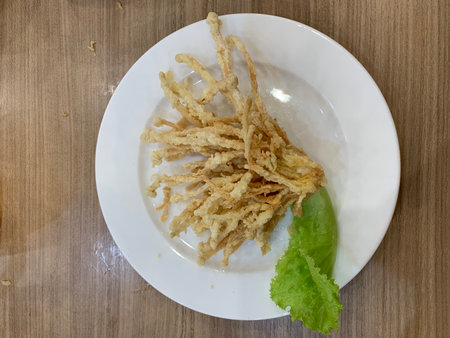 Fried food on white plate on wooden table. Top view.の写真素材