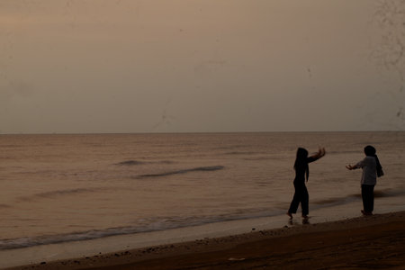 Silhouette of two women on the beach in the evening.
