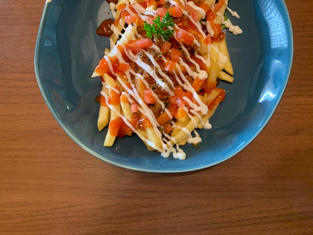 Pasta with tomato sauce and cheese on a blue plate on a wooden table