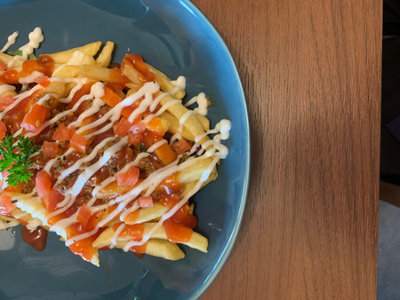 French fries with tomato sauce on a blue plate, top view.