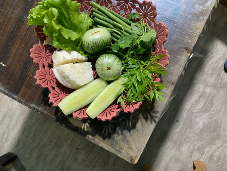 Thai style vegetable salad in a bowl on a wooden table.の写真素材