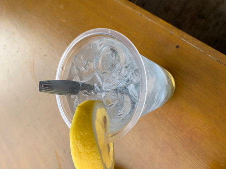 Ice lemonade in a glass on a wooden table, top viewの写真素材