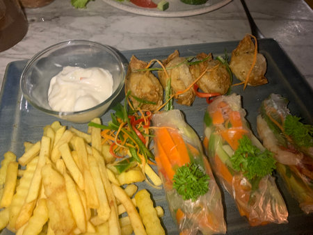 Vietnamese spring rolls and french fries with sour cream sauce.