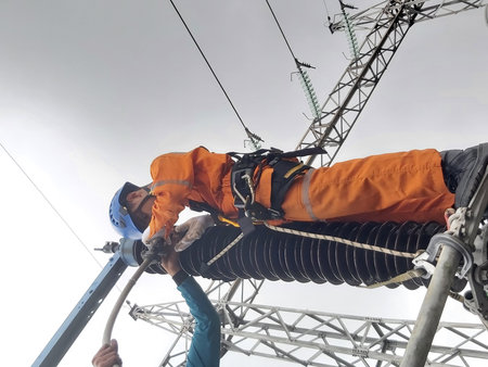 Electricians working on high-voltage substation. Electricity distribution station.