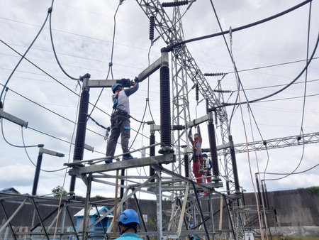 Electricians are working on the high voltage power line in Thailand.