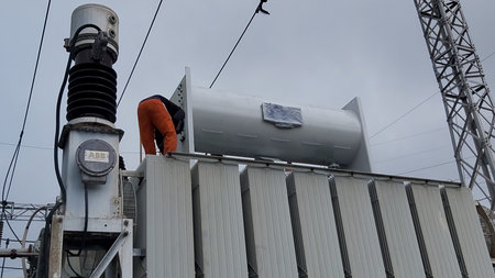 Electrician working on a power transformer in a substation. Electricity distribution station.