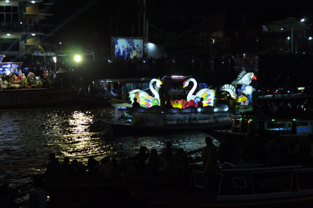 Unidentified Thai people floating on the Chao Phraya River at night.