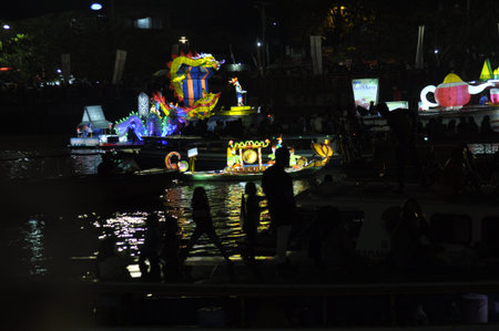 Unidentified Thai people floating on the Chao Phraya River at night in Bangkok, Thailand.