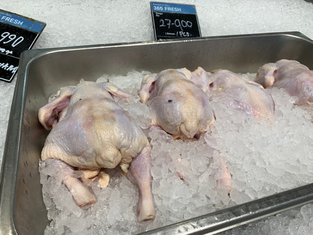 Fresh raw chicken on ice in a supermarket, closeup of photoの写真素材