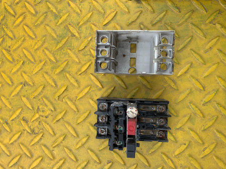 Electrical junction box on the yellow steel floor, top view.