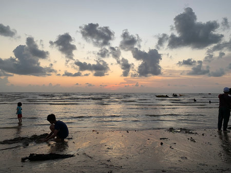 Silhouette of children playing on the beach in the evening.