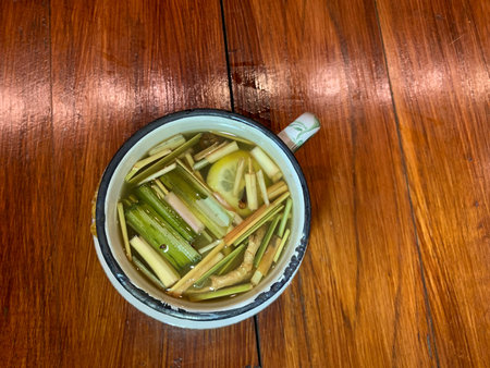 Cup of tea with lemon and celery on a wooden tableの写真素材