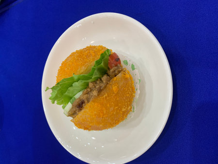 Fried fish cake on a white plate on blue tablecloth.の写真素材