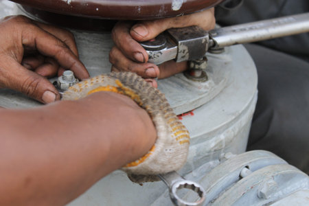 Close up of a man's hands fixing an old oil tank.の写真素材