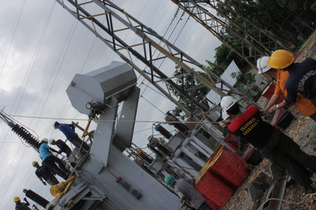 Unidentified workers are working on electric pole in Chiang Mai, Thailand.