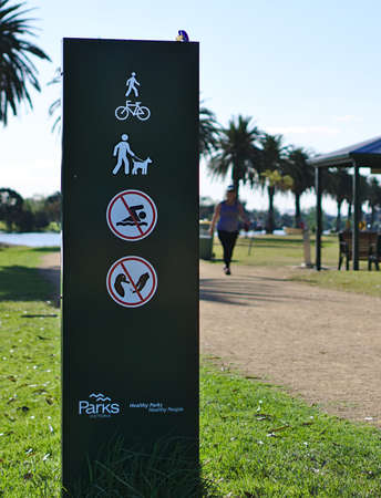Albert Park, VIC / Australia - Oct 21 2018: Shared path, dogs on leash, no swimming, no feeding sign at Albert Park Lakeのeditorial素材