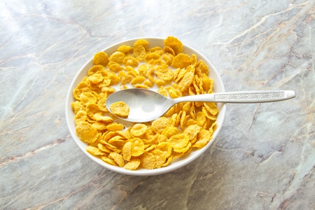 bowl of cereal with milk on stone background
