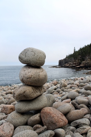 stacked rocks in balance near the ocean side on the beachの写真素材