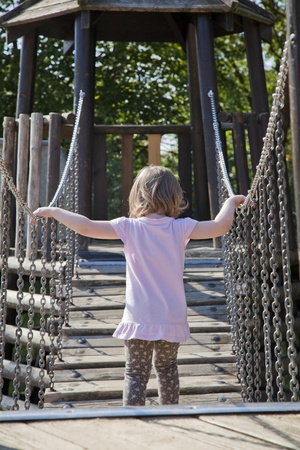 small baby girl balancing on a wooden bridgeの写真素材