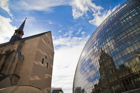 church reflecting in the galss of a business center on a blue sky backgroundのeditorial素材